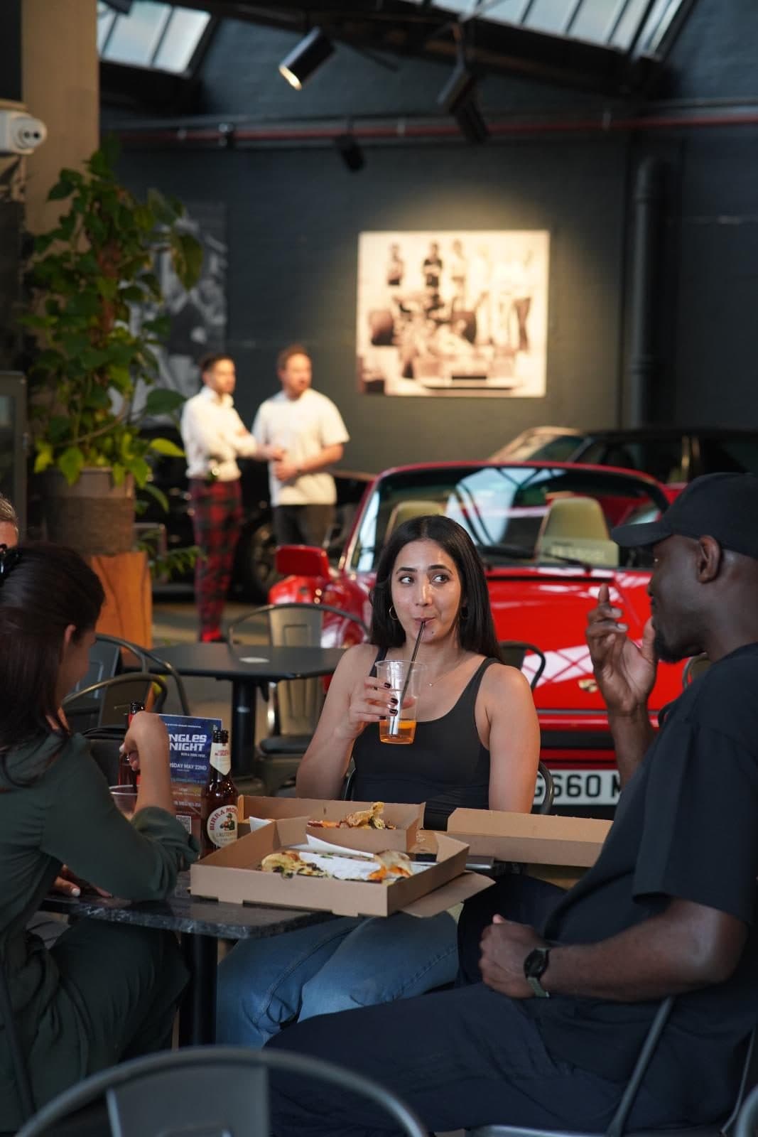 Guests eating pizza in the showroom at Porsche 'N Pizza Night