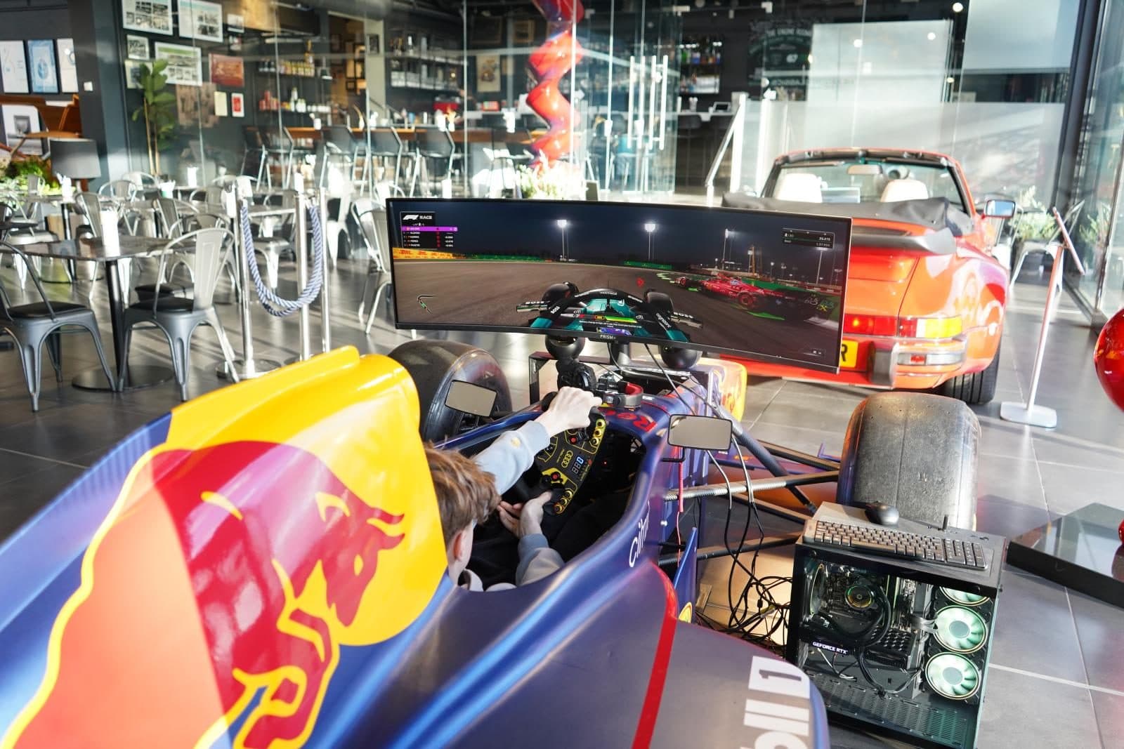 The F1 simulator set up in front of a classic Porsche